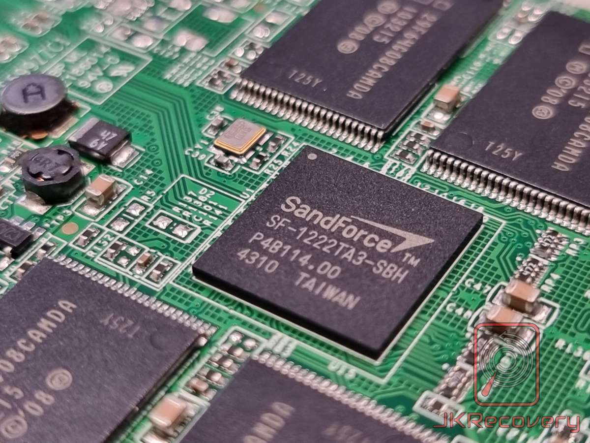 Zbliżenie na kontroler SandForce SF-1222TA3-SBH zamontowany na zielonej płycie PCB dysku SSD Corsair Force F120, wyprodukowany na Tajwanie, oznaczony P4B114.00, otoczony kośćmi pamięci flash NAND