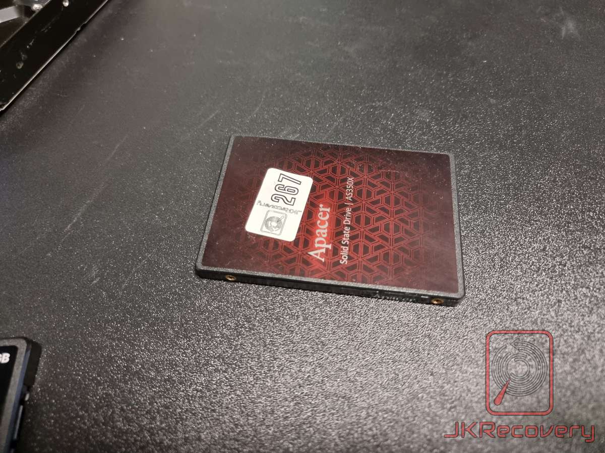 Dysk SSD Apacer AS350X w obudowie 2.5 cala, widok od przodu z charakterystyczną czerwono-czarną naklejką w geometryczny wzór oraz białą etykietą serwisową z numerem 267