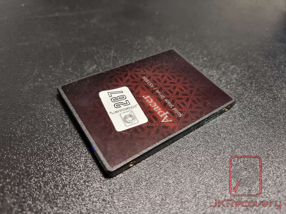 Dysk SSD Apacer AS350X w obudowie 2.5 cala, widok od tyłu z czerwono-czarną naklejką w geometryczny wzór oraz białą etykietą serwisową z numerem 267