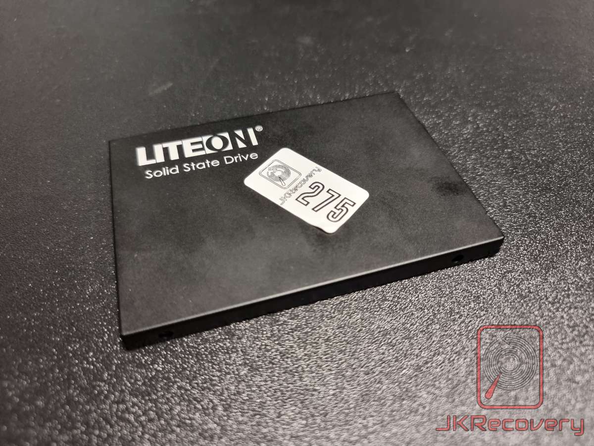 Dysk SSD 2.5 cala marki LiteOn z naklejką inwentaryzacyjną JKRecovery o numerze 275, leżący na czarnej macie laboratoryjnej