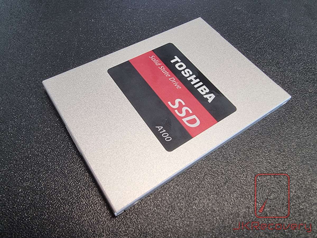 Wierzch dysku SSD Toshiba A100 w srebrnej obudowie z czarno-czerwoną naklejką identyfikacyjną