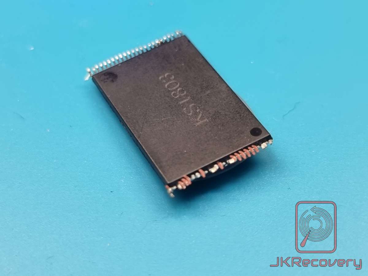 Układ scalony NAND Flash w obudowie TSOP48 z oznaczeniem K91803, widok od spodu z widocznymi uszkodzonymi/przygiętymi pinami, leżący na niebieskim tle - laboratorium JKRecovery