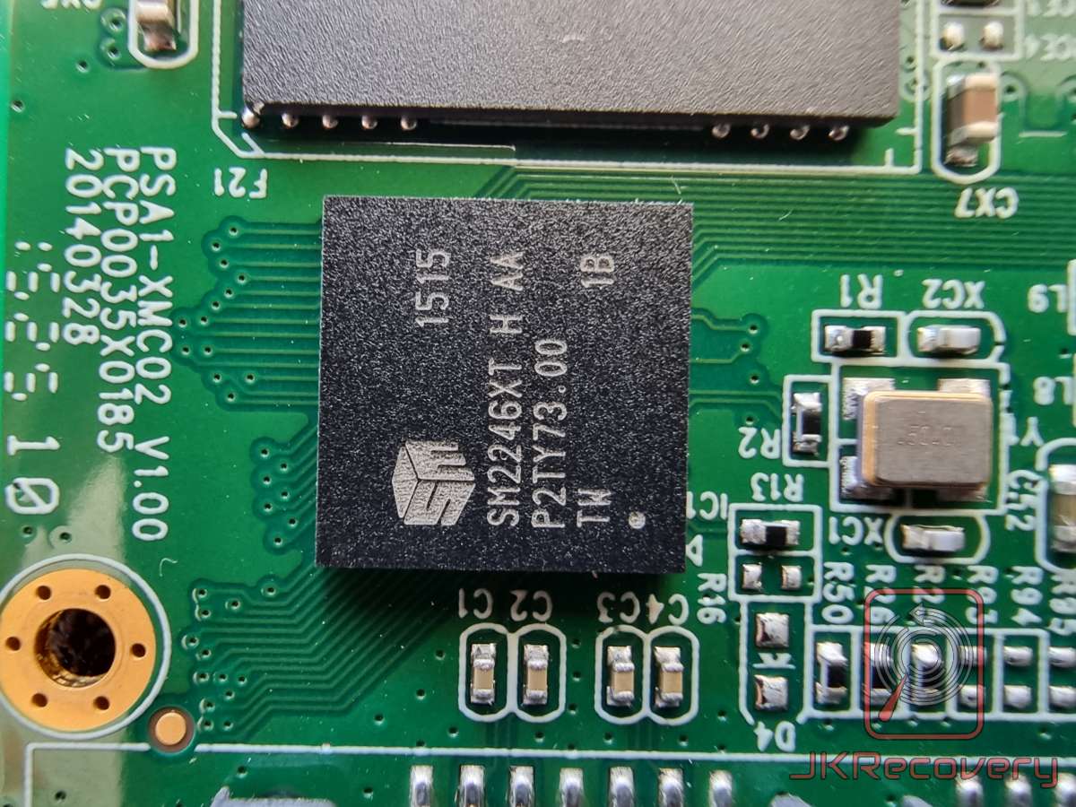 Zbliżenie na kontroler SSD Silicon Motion SM2246XT zamontowany na zielonej płytce PCB. Widoczne oznaczenia układu scalonego: SM2246XT H AA, P2TY73.00, data produkcji 1515. Na płytce widoczny numer seryjny PSA1-XMC02 V1.00, PCP0035X0185, 20140328.