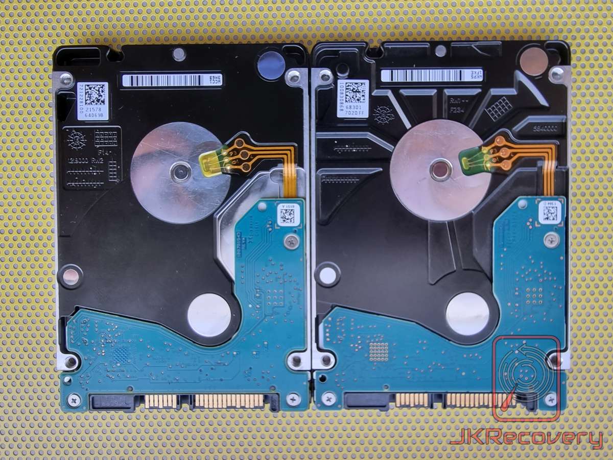Dwa dyski twarde HDD 2.5 cala widoczne od spodu – porównanie płyt PCB w kolorze niebieskim, widoczne złącza SATA, cewki głowic z kablami flex oraz magnesy neodymowe, prawdopodobnie dysk donor i dysk pacjent do odzysku danych