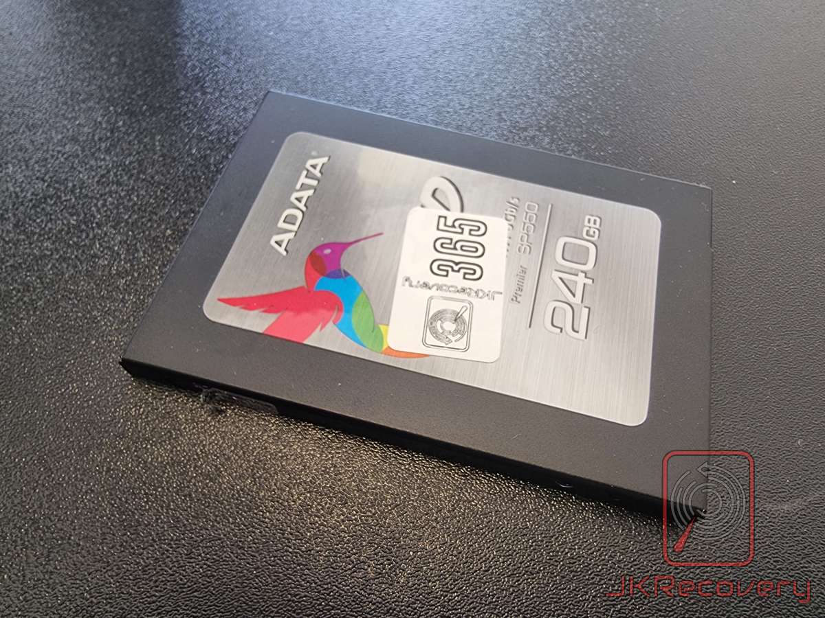Dysk SSD ADATA Premier SP550 240GB w czarnej obudowie 2.5 cala z kolorowym logo kolibra, leżący na czarnej powierzchni w laboratorium odzysku danych JKRecovery
