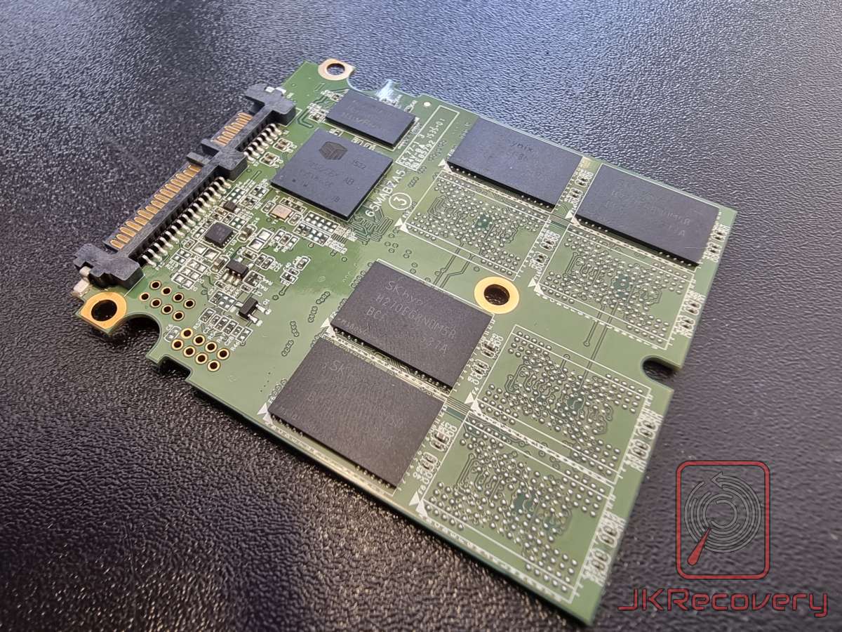 Płyta PCB dysku SSD 2.5 cala widziana pod kątem z widocznymi kośćmi pamięci flash SK Hynix oraz kontrolerem Silicon Motion