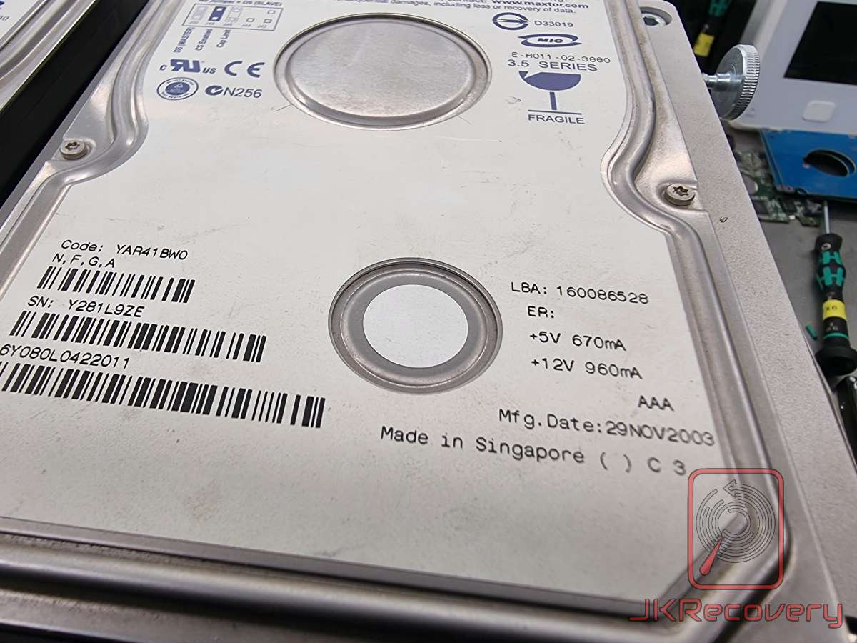 Zbliżenie na dysk twardy Maxtor 3.5 Series o pojemności około 80GB (LBA: 160086528), wyprodukowany 29 listopada 2003 roku w Singapurze, z widocznym numerem seryjnym Y281L9ZE i kodem YAR41BW0, leżący na stanowisku laboratoryjnym firmy JKRecovery