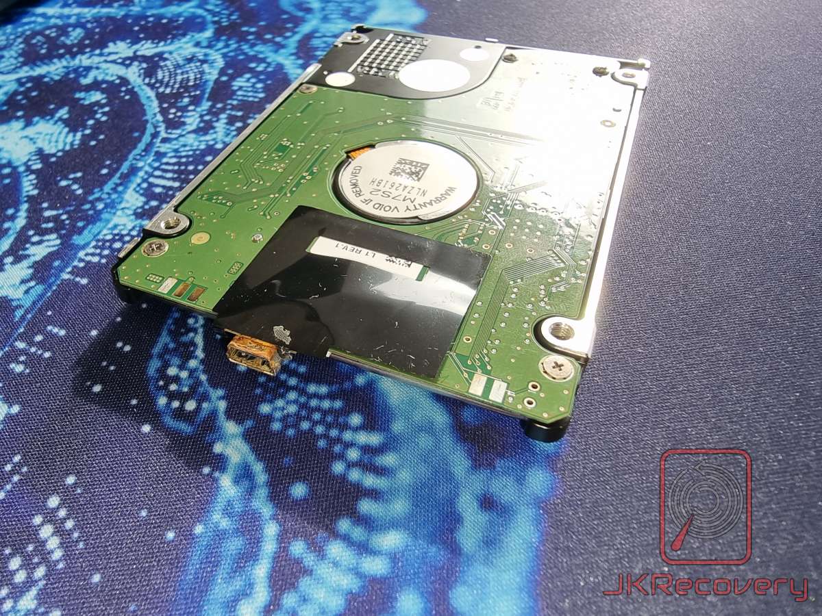 Dysk twardy Samsung 2.5 cala widoczny od spodu z płytą PCB, widoczne uszkodzenie elementu elektronicznego przy złączu SATA w postaci przepalonego kondensatora lub rezystora