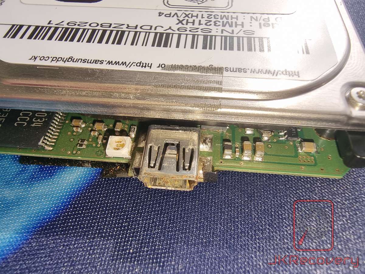 Uszkodzony port mini-USB na płytce PCB zewnętrznego dysku twardego Samsung HM321HX - widoczne korozja i uszkodzenia mechaniczne złącza
