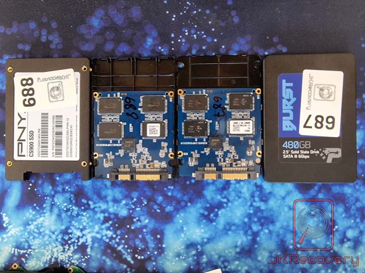 Cztery dyski SSD 2.5 cala rozłożone na blacie - dwa z obudowami (PNY CS900 960GB oznaczony numerem 688 oraz Patriot Burst 480GB oznaczony numerem 687) oraz dwie odsłonięte płyty PCB z kontrolerami Phison i układami pamięci NAND, oznaczone numerami 689 i 689, przygotowane do odzysku danych przez JKRecovery