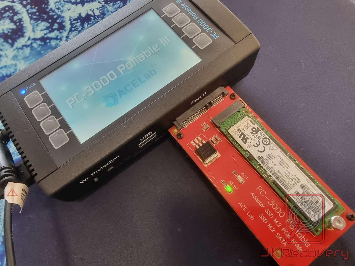 Urządzenie PC-3000 Portable III firmy ACELab z podłączonym adapterem M.2 NVMe (czerwona płytka ACE Lab) oraz dyskiem SSD M.2 NVMe Samsung 256GB podczas diagnostyki w laboratorium odzysku danych JKRecovery