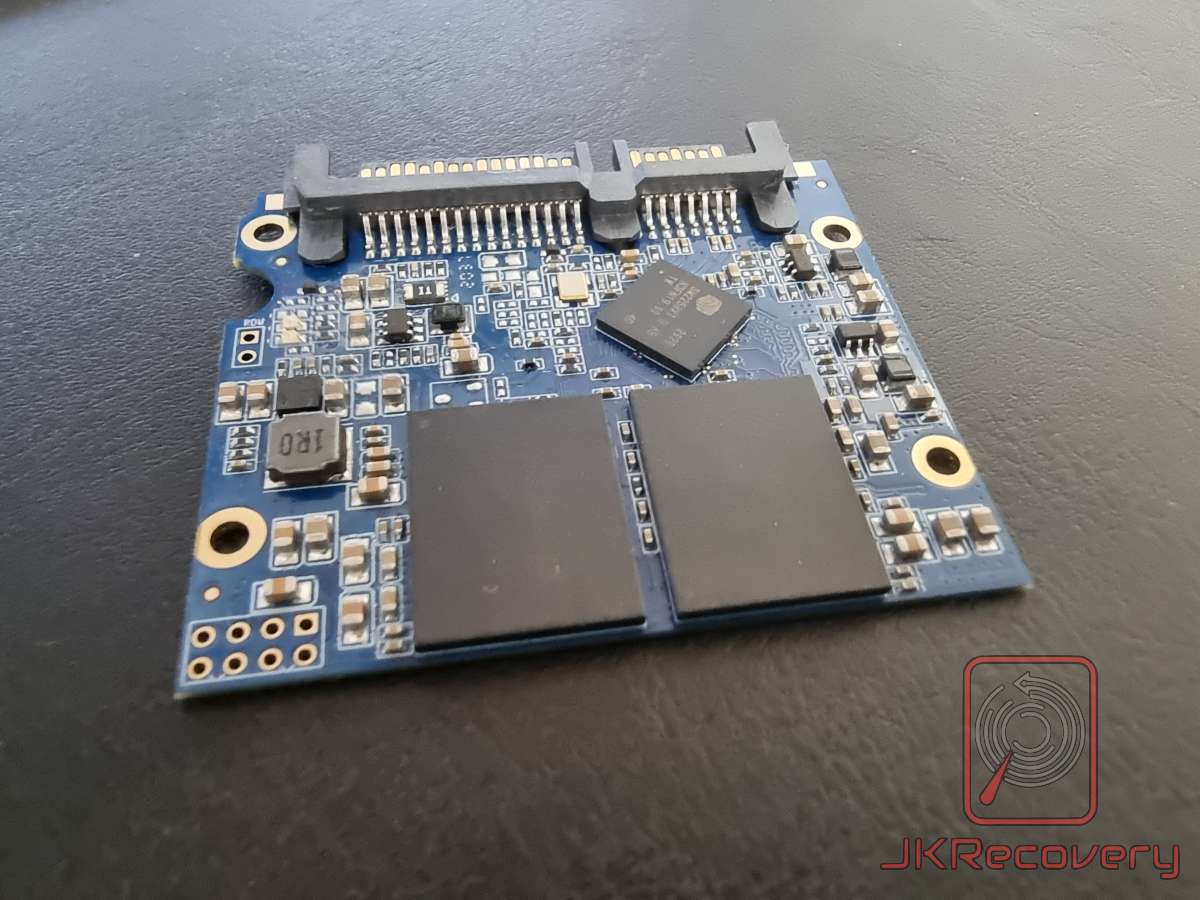 Płyta PCB dysku SSD 2.5 cala z interfejsem SATA, widoczne dwa układy pamięci NAND flash oraz kontroler, zdjęcie od strony komponentów