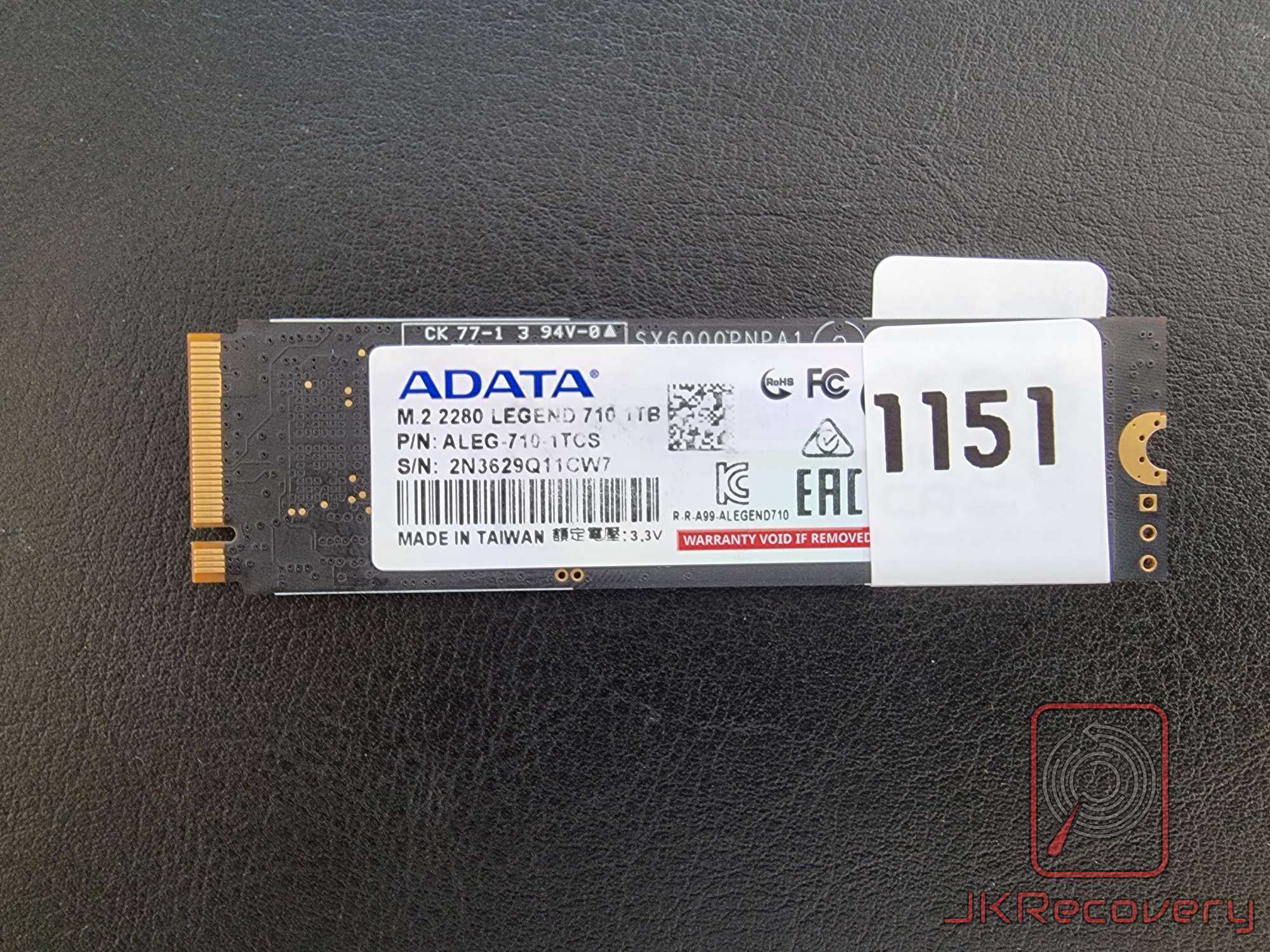 Spód dysku SSD NVMe ADATA Legend 710 1TB M.2 2280 z naklejką producenta zawierającą numer seryjny 2N3629Q11CW7 oraz etykietą inwentaryzacyjną JKRecovery z numerem 1151