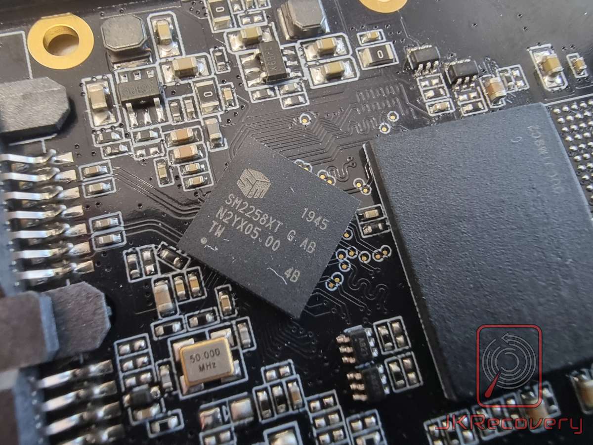 Zbliżenie na kontroler SSD Silicon Motion SM2258XT zamontowany na płytce PCB, widoczny kryształ oscylatora 50MHz oraz elementy SMD