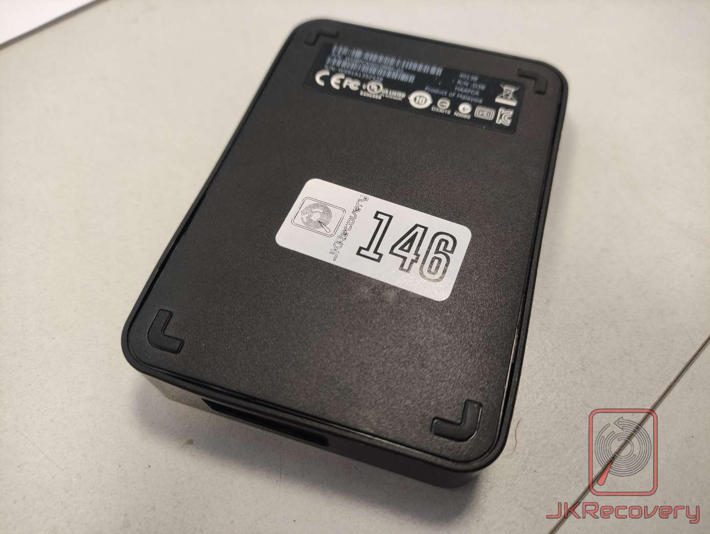 Zewnętrzny dysk twardy HDD w czarnej obudowie, wyprodukowany w Malezji, oznaczony numerem 146 przez laboratorium JKRecovery