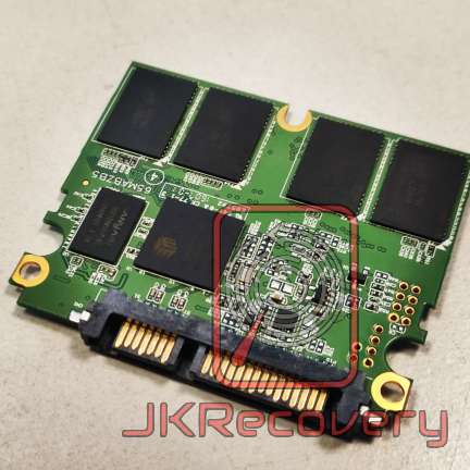 Płytka PCB dysku SSD z widocznym uszkodzonym kontrolerem oznaczonym czerwoną ramką oraz układami pamięci NAND flash