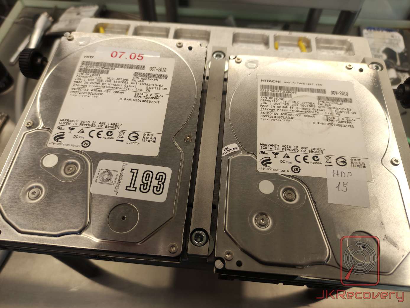 Dwa dyski twarde Hitachi HDS721010CLA332 o pojemności 1TB każdy, wyprodukowane w 2010 roku, umieszczone obok siebie na stanowisku laboratoryjnym podczas procesu odzysku danych - jeden oznaczony numerem 193, drugi opisany jako HDP 15