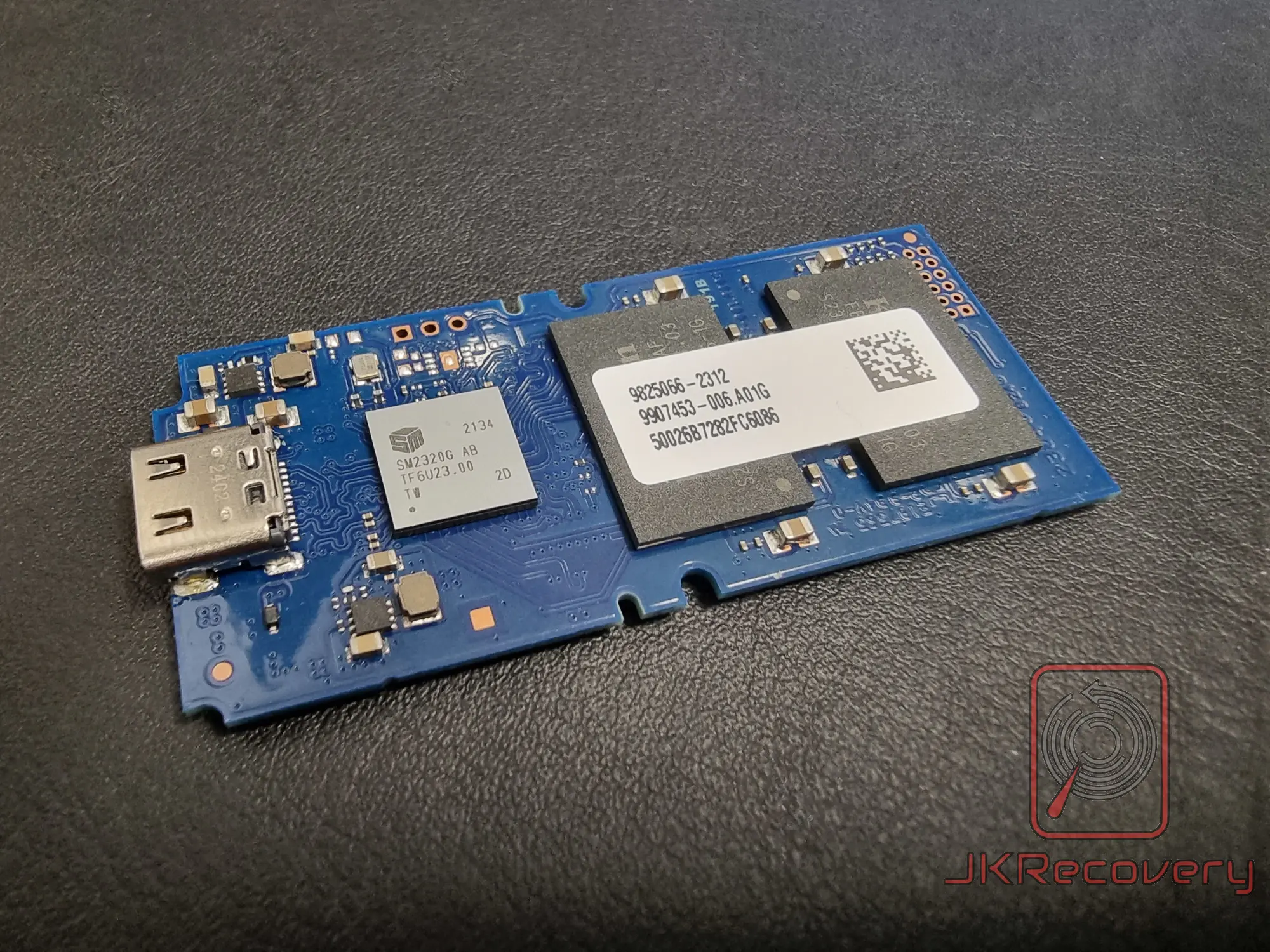 Płytka PCB pendrive'a z widocznym kontrolerem SM2320G AB oraz układem pamięci flash z etykietą 9825066-2312, złącze USB typu A po lewej stronie
