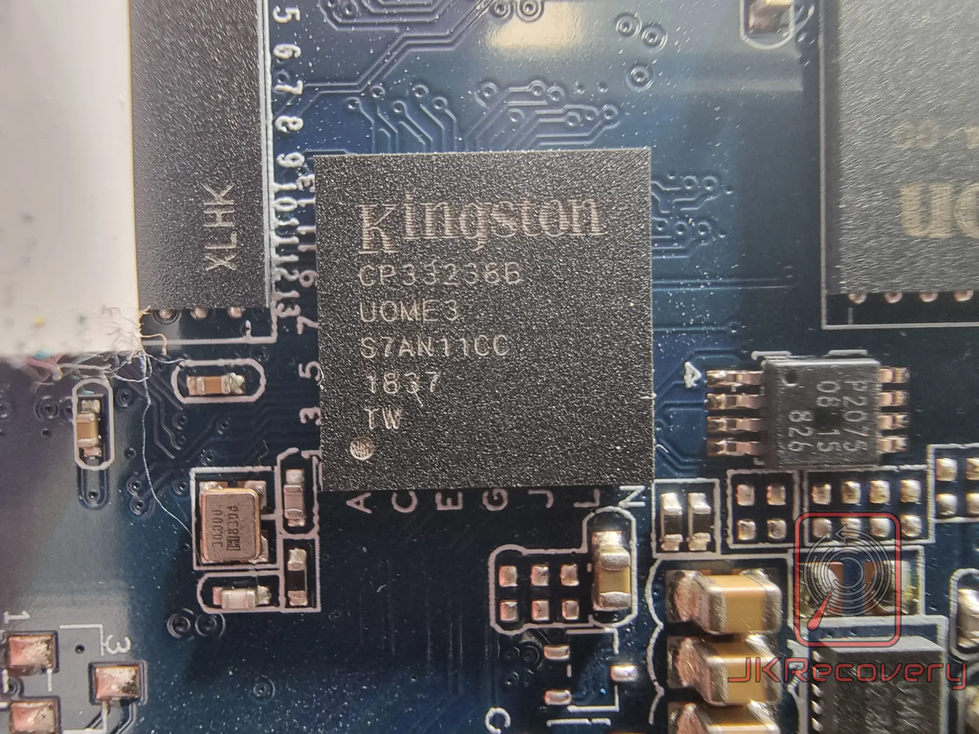 Zbliżenie na kontroler SSD Kingston CP33238B UOME3 S7AN11CC zamontowany na niebieskiej płytce PCB dysku SSD